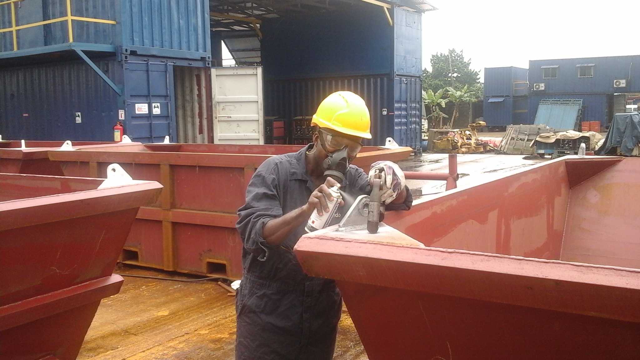 welder-spray-painting-padeye-on-waste-skip